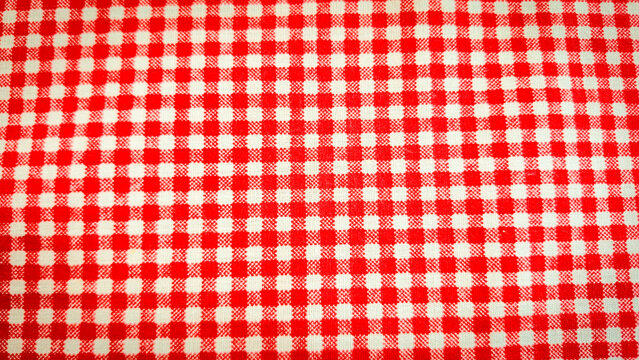 A seamless red and white gingham checkered pattern featuring alternating squares in a classic grid layout