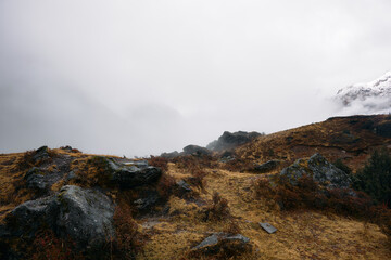Cloudy landscape with rocks and grass in a mountainous area during daytime