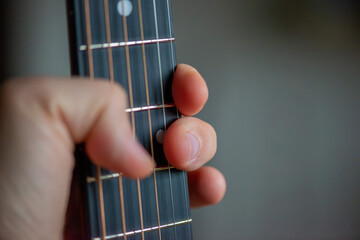 A sharp close-up photograph of an acoustic guitar highlighting its strings, wood texture, and...