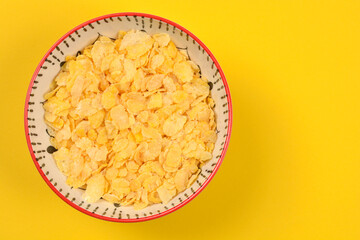 A high-angle, close-up shot of a white ceramic bowl with a red rim and black pattern, filled with...