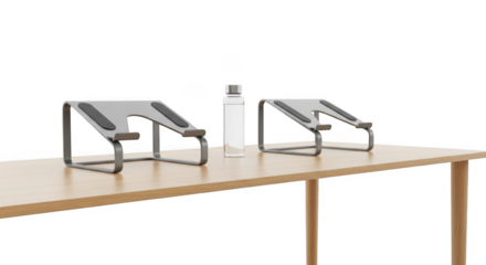 Two modern gray metal laptop stands and a white water bottle on a wooden table isolated on transparent background