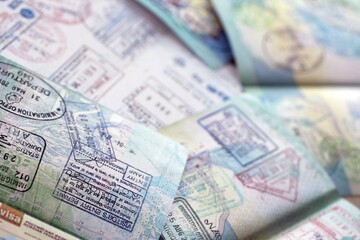Many open passport pages with lots of visas and entrance stamps from various countries passport control. Concept of travel and tourism worldwide