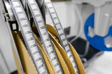 Packaging of plastic tape in tape-and-reel format for surface mount technology components in a manufacturing facility