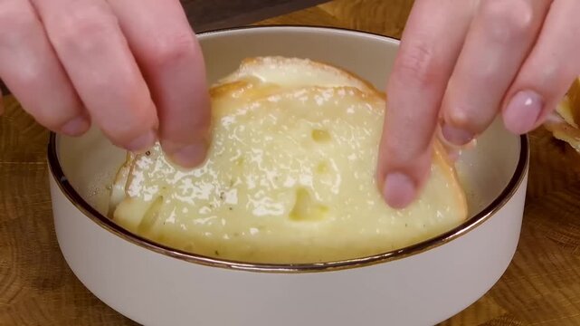 Dipping ham and cheese sandwich into egg mixture for french toast preparation