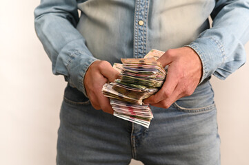 Person firmly holds oversized stacks of banknotes, representing significant monetary resources, strong financial theme, savings and cash accumulation. Ukrainian money, concept of corruption.