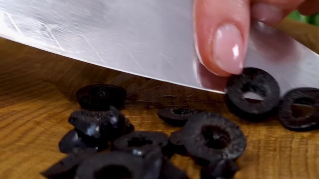 Decorating cheese ham sandwiches with sliced black olives and cherry tomatoes on tray