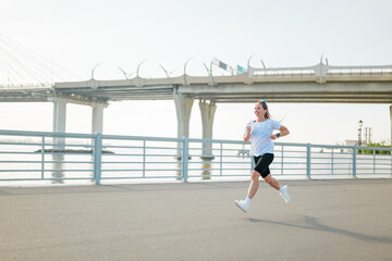Fototapeta premium Runner enjoys exercise along waterfront path