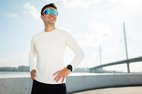 Man enjoys outdoor workout near a bridge by the river - Powered by Adobe