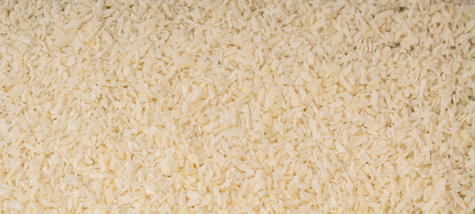 Grated coconut powder. Dry coco flakes pile, shredded desiccated coconut, tropical fruit chips