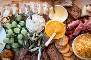 Charcuterie Board With Fresh Bread, Grapes, Sauces, Pickles, and Snacks