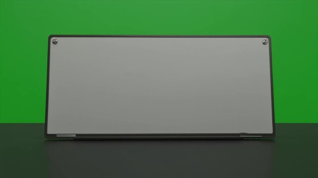 Modern laptop with blank screen on green background and dark surface.