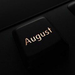A close-up of a keyboard with the word "August" highlighted on a black key