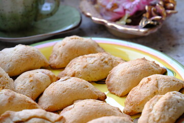 Fresh apple cookies, fresh from the oven. A Turkish-embroidered napkin with a pink ribbon. A pink floral decorative plate. Homemade cookies. Turkish cuisine. Tea time. Ramadan iftar. A green cup.