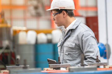 Inspecting industrial machinery worker in factory photography manufacturing environment close-up view safety and precision