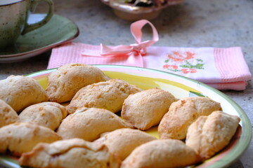Fresh apple cookies, fresh from the oven. A Turkish-embroidered napkin with a pink ribbon. A pink floral decorative plate. Homemade cookies. Turkish cuisine. Tea time. Ramadan iftar. A green cup.