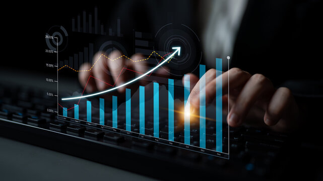 A business professional hands typing on a keyboard, surrounded by a virtual graph overlay symbolizing finance growth and digital innovation in a modern office setting. Scalp - Powered by Adobe