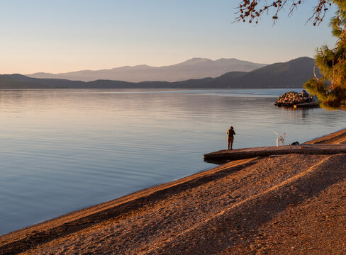 A female fisherman fishing in the Aegean Sea at sunset on Evia Island in Greece 