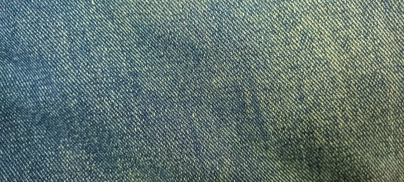 Close-up view of a blue woven textile material showcasing its intricate texture and diagonal pattern, providing a versatile background for design projects and fashion concepts