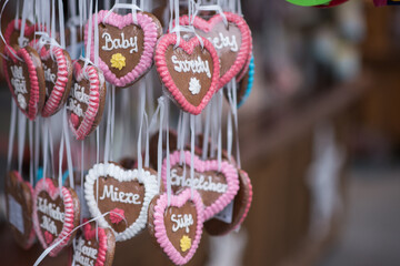 Christmas tree decorations.Assortment of traditional German gingerbread hearts (Lebkuchenherzen) hanging on ribbons. Close-up view of colorful holiday sweets with frosted messages