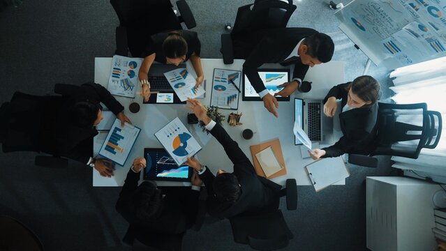 Top view of businesswoman sit at seat and start to analyze stock market data with diverse business team at meeting table with marketing chart document and tablet display financial report. Directorate. - Powered by Adobe