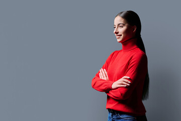 Profile portrait of young confident woman on gray background