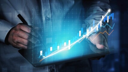 A businessman engages with digital financial data, utilizing graphs and charts displayed on a tablet, representing growth and trends in a modern office setting. Copula