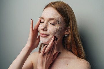 Serene woman gently washing face with bubbles during calming evening ritual
