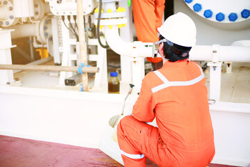 Technician monitor and command by radio to operator on job site in oil and gas industry, Worker in oil and gas industry contact to operation team to check condition of the machine, with warm light.