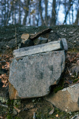 Stacked stones create a natural sculpture in a serene forest setting, surrounded by fallen leaves...
