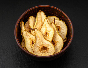 A bowl of pear chips. Isolated on a black background.