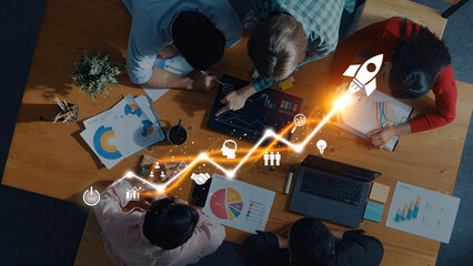 A dynamic business team engages in collaboration, analyzing data visualizations and growth projections during a strategy meeting. The atmosphere fosters innovation and teamwork. Trope