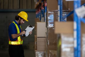 Warehouse worker using barcode scanner and clipboard to check inventory on shelves. Concept of inventory inspection, logistics accuracy and efficient warehouse management system.
