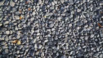 Black river rock gravel used in garden landscaping and drainage