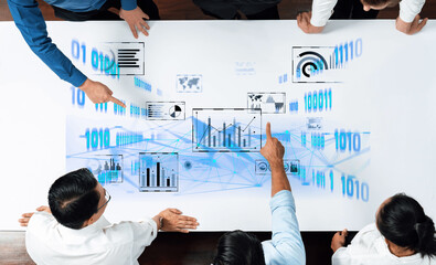 A diverse business team collaborates around a digital table, analyzing data insights through interactive graphs and charts for informed decision-making. Trope