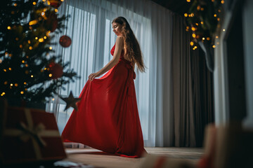 woman with present near Christmas tree indoors