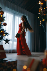 woman with present near Christmas tree indoors