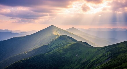 Scenic view of mountain peaks under a dramatic sky with sun rays, creating a beautiful natural landscape.