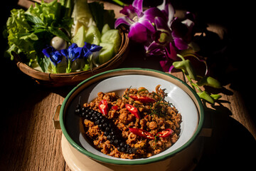 A plate of traditional Southern Thai Khua Kling stir-fried minced pork served in a rustic bowl, topped with red chili and sliced kaffir lime leaves. 