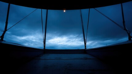 A view through the upper rim of an empty Ferris wheel at dusk