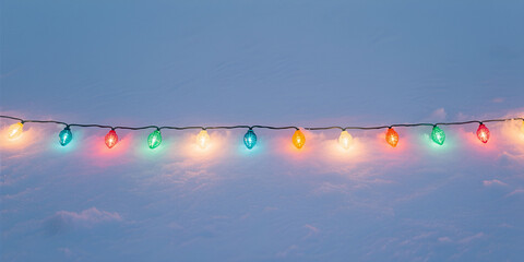 Cordone di luci ornamentali festive e colorate su una superficie ricoperta di neve
