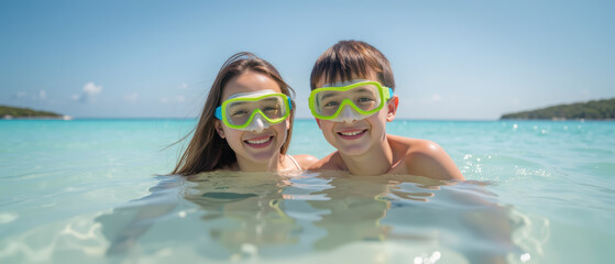 Enjoying sunny day at beach, two children wear colorful snorkeling gear while swimming in clear turquoise water