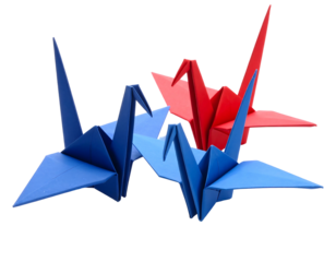 Three colorful paper cranes in origami style, with one red and two blue, artfully arranged on a black background