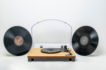 Turntable with two vinyl records arranged symmetrically, retro analog music concept in clean studio composition.