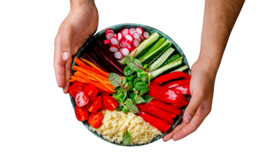 Healthy colorful vegetable bowl being held with hands against a white background