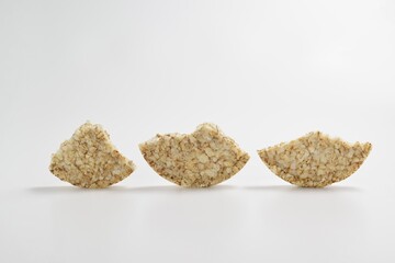Pieces of broken buckwheat crispbread on a white background
