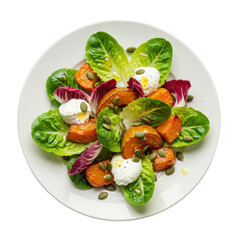 Gourmet autumn salad with lettuce, radicchio, roasted pumpkin, goat cheese, pumpkin seeds, golden vinaigrette, flat lay on white plate, white background. Autumn healthy food concept