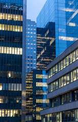 Obraz premium Office building facade with illuminated windows in morning light