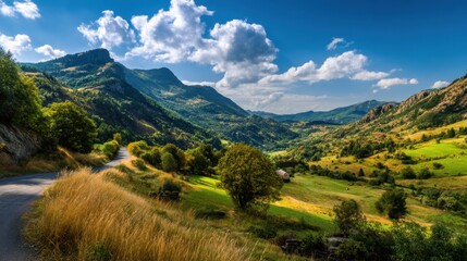 Fototapeta premium Vibrant mountain scenery features a winding road surrounded by green valleys and trees. Puffy clouds float above the peaks showcasing a serene and picturesque view.