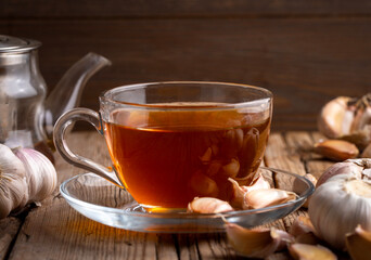 Cup of healthy garlic tea on table