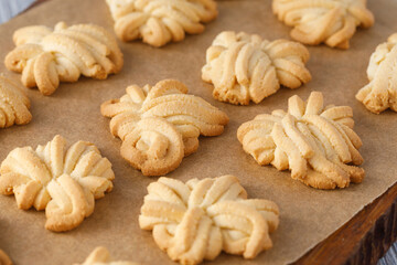 Homemade butter spritz cookies baking on parchment paper